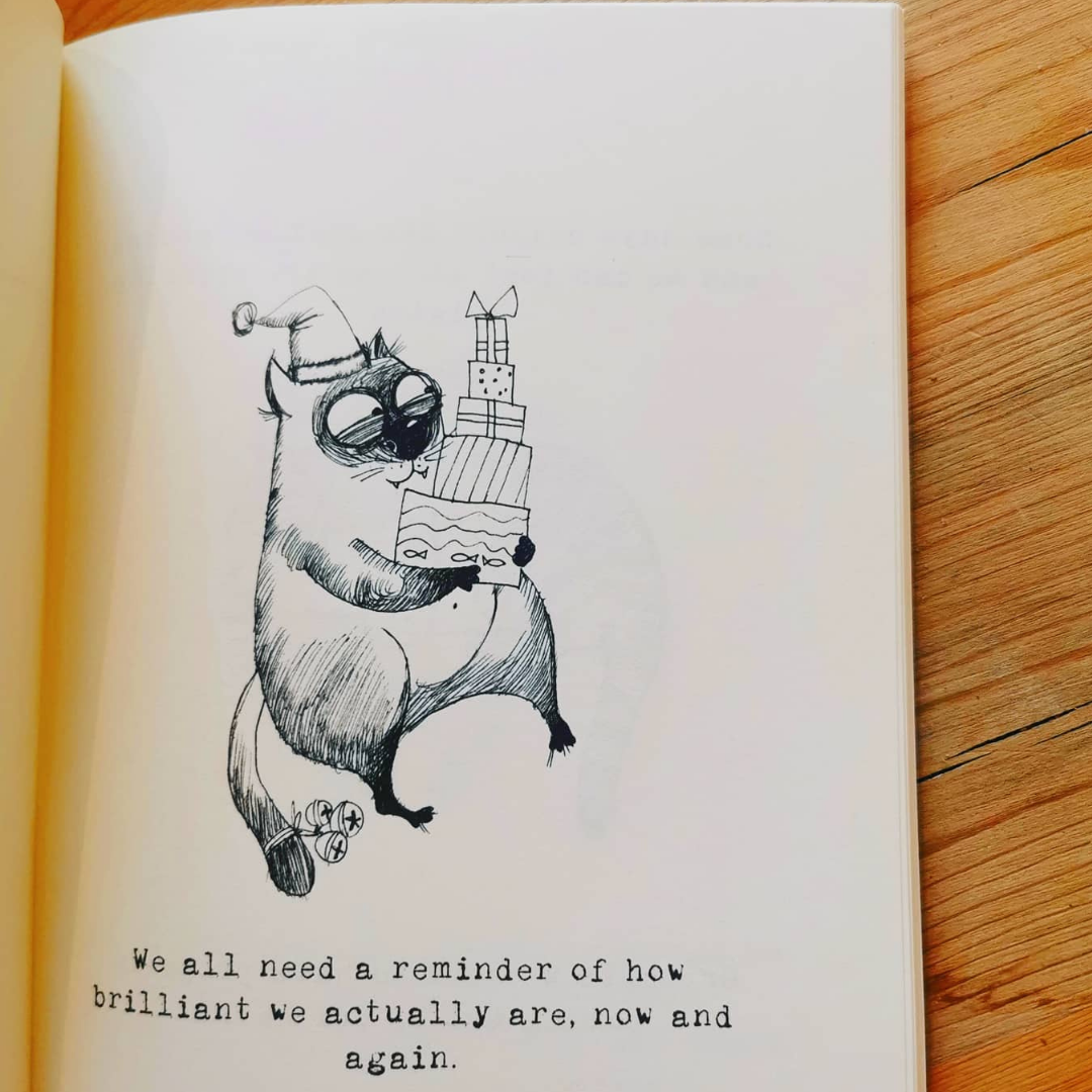 Open page of the gift book for veterinary professionals showing an ink-drawn cat in a party hat carrying a stack of presents